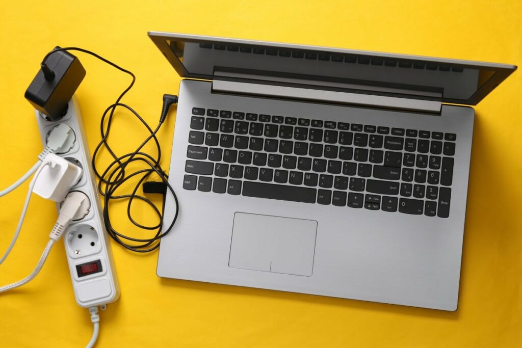 Ein Laptop und andere Geräte sind an eine Mehrfachsteckdose angeschlossen.