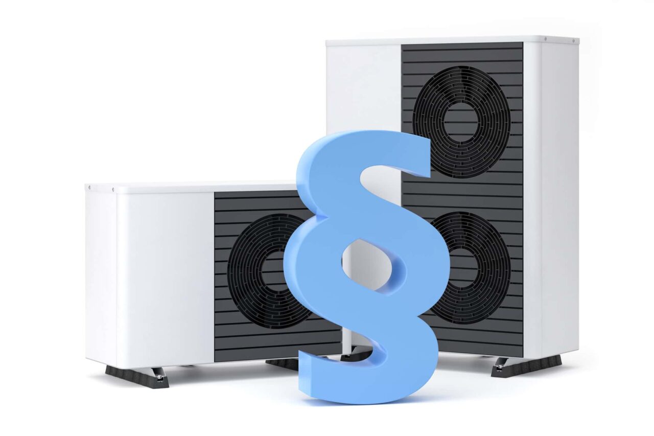 Heizungsgesetz: Ein Paragrafsymbol vor zwei Wärmepumpen